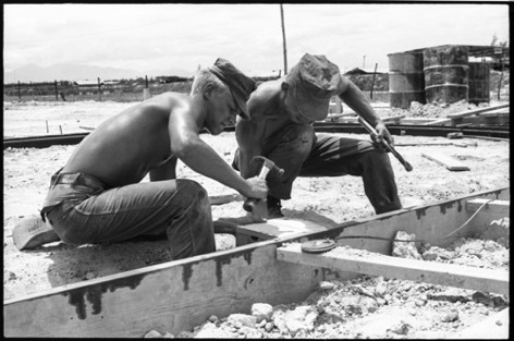 Carpenters Mollett and Childs frame up the permiter for the concrete foundation for one of the pre-fab barracks (see below).